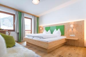 a bedroom with a bed with a green headboard at Landhaus Sunseitn in Ramsau am Dachstein