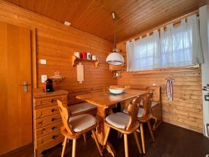 a wooden kitchen with a wooden table and chairs at Toggi EG in Bettmeralp