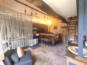 CorseulにあるLa Ville Es Riez Gite au pressoirのソファ、テーブル、椅子が備わる客室です。