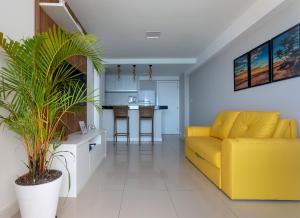 a living room with a yellow couch and a kitchen at Casa da Geo Ondina - Frente de Praia in Salvador