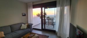 a living room with a couch and a view of a balcony at Arenas de Doñana by Sanlúcar Housing in Sanlúcar de Barrameda