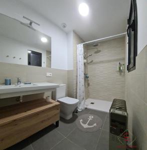a bathroom with a sink and a toilet and a shower at Arenas de Doñana amplio apartamento frente del mar in Sanlúcar de Barrameda