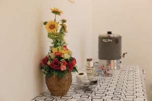 un vaso con composizione floreale su un bancone di The Original Orange Hotel a Nakhon Si Thammarat