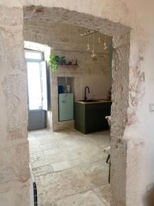 a kitchen with a green refrigerator in a stone wall at La Casetta in Alberobello