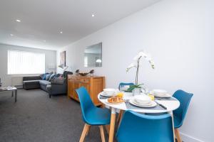 a living room with a table and blue chairs at Entire home in Downend, Bristol in Bristol