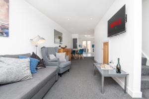 a living room with a couch and a tv on a wall at Entire home in Downend, Bristol in Bristol