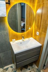 a bathroom with a sink and a mirror at Fly Apartment in Prigorodnyy