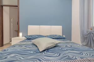 een blauw en wit bed met een kussen erop bij SweetHomeSaronno-A 20 minuti da Milano in Saronno