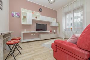 een woonkamer met een rode bank en een televisie bij SweetHomeSaronno-A 20 minuti da Milano in Saronno