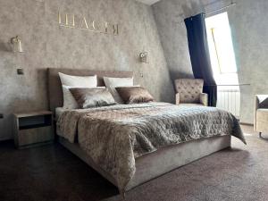 ein Schlafzimmer mit einem großen Bett und einem Stuhl in der Unterkunft Готельно-ресторанний комплекс Щастя in Poltawa