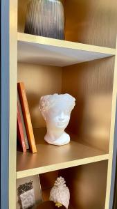 um vaso branco numa prateleira com livros em Vanilla Studio em Timisoara