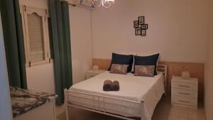 een slaapkamer met een bed met schoenen erop bij Casa Mendes in Tarrafal