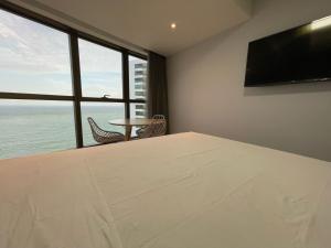 um quarto com uma grande janela e uma mesa e cadeiras em BEIRA MAR- FLAT EXECUTIVE no Recife