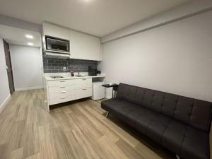 uma sala de estar com um sofá e uma cozinha em BEIRA MAR- FLAT EXECUTIVE no Recife