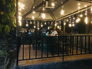 deux personnes assises à un bar sous les lumières dans l'établissement BABA lodge & restaurant, à Sauraha