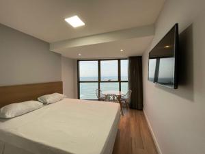 een slaapkamer met een bed en uitzicht op de oceaan bij BEIRA MAR- FLAT EXECUTIVE in Recife