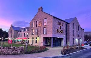 a large brick building with a blue and root at Bike & Boot Inns Peak District - Leisure Hotels for Now in Castleton