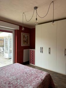 a bedroom with a bed and a red wall at ElleCi Casa Vacanze in Mondovì