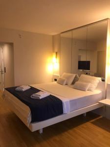 a bedroom with a large bed with mirrored walls at Orbi apartament in Batumi