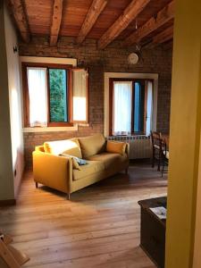 un soggiorno con divano giallo e finestre di MiVà casa di charme sul Brenta a Mira
