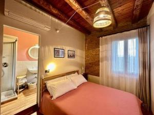 1 dormitorio con cama roja y baño en MiVà casa di charme sul Brenta, en Mira