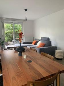 uma sala de estar com uma mesa de madeira e um sofá em Lovely room in Nanterre Université em Nanterre