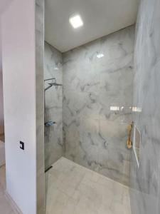 a bathroom with a shower with a glass door at Villa Nour Kélibia in Kelibia