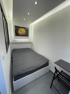 a small bedroom with a bed and a table at MoonYellow - Basel - AirPort - HighQuality in Saint-Louis