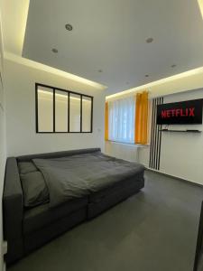 a bedroom with a bed and a netflix sign on the wall at MoonYellow - Basel - AirPort - HighQuality in Saint-Louis