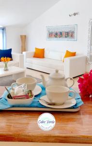 ein Wohnzimmer mit einem Tee-Set auf dem Tisch in der Unterkunft Branco Suites - Rooms & Holiday Apartments in Santa Maria