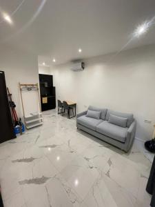 a living room with a couch on a marble floor at Studio à 250 metres du casino de Monaco in Beausoleil