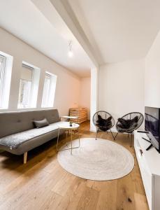 ein Wohnzimmer mit einem Sofa und 2 Stühlen in der Unterkunft Apartman Snowhite Bjelasnica in Bjelašnica