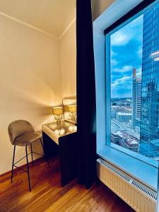 Zimmer mit einem Fenster mit einem Tisch und einem Stuhl in der Unterkunft High-Rise Amazing View Apartment 14th Floor In CityCentre in Tallinn