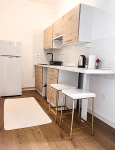 eine Küche mit einem Tisch, 2 Stühlen und einem Kühlschrank in der Unterkunft Apartman Snowhite Bjelasnica in Bjelašnica