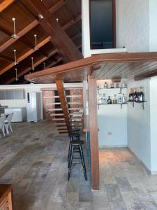Una habitación con un bar con una silla y un televisor. en Casa de praia Peruibe, en Peruíbe