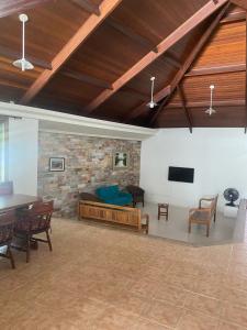 Una sala de estar con un sofá y un televisor. en Casa de praia Peruibe, en Peruíbe