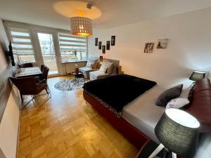 a bedroom with a bed and a living room at Sunset View Apartment with Logia in Ettlingen