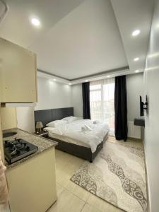 een slaapkamer met een bed en een keuken met een fornuis bij Hermes Otel in Edirne