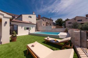 a backyard with a swimming pool and a house at Villa Santina by Briskva in Višnjan