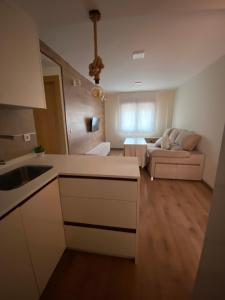 a kitchen and living room with a couch in the background at APARTAMENTO NEVADA in Pinos Genil