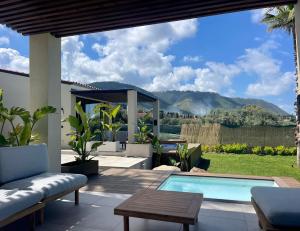 a patio with a swimming pool and a table at Insulae Resort in Cefalù