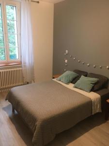 sypialnia z dużym łóżkiem z zielonymi poduszkami w obiekcie Manoir en Pierre Chartres w mieście Chartres