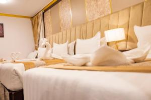 a hotel room with three beds with white pillows at Odst Al Madinah Hotel in Al Madinah