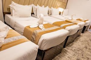 a row of beds in a hotel room at Odst Al Madinah Hotel in Medina