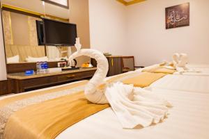 a hotel room with two beds with swans on them at Odst Al Madinah Hotel in Al Madinah