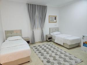 1 Schlafzimmer mit 2 Betten und einem Teppich in der Unterkunft شقق مفروشة in Medina