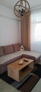 - un salon avec un canapé et une table basse dans l'établissement Apartman 'CENTAR', à Kula