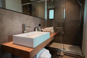 a bathroom with a white sink and a shower at Insulae Resort in Cefalù