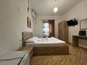 Dormitorio pequeño con cama y TV en Hotel Apostoli en Përmet