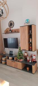 - un centre de divertissement avec une télévision et un sapin de Noël dans l'établissement Apartman 'CENTAR', à Kula